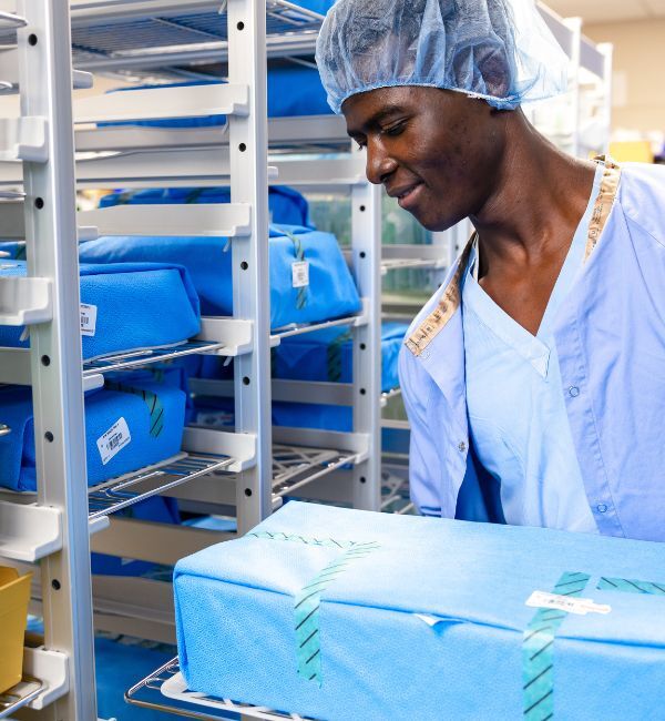 SPD tech handling wrapped surgical instrument loaner tray
